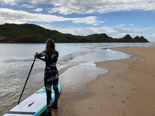 Paddle boarder at Three Cliffs Bay Gower.