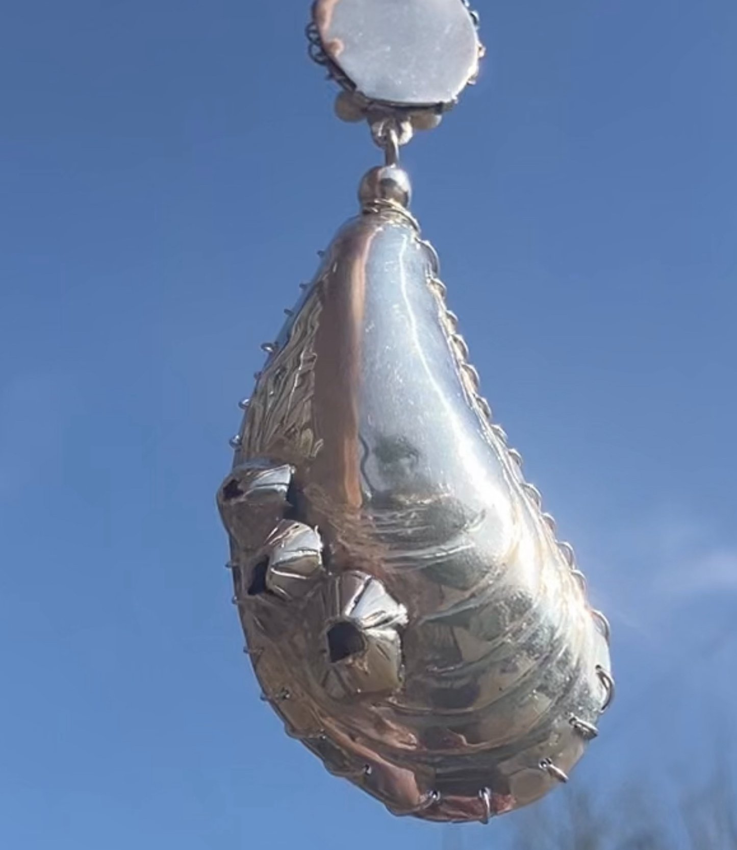 Silver mussel shell pendant with pearls sewn inside